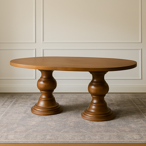 Evora Dining Table in Hard Maple with a double pedestal base and an oval top, displayed in a modern rustic room with paneled cream walls and a neutral textured rug.